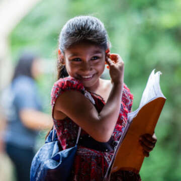 10-year old Natalia smiles shyly as she reads from her workbook at a Save the Children sponsorship-funded program in El Salvador. The program targets young boys and girls and helps them discover alternative views of conventional gender roles and behaviors. Photo credit: Victoria Zegler / Save the Children, November 2016.