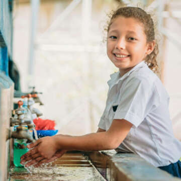 Little Britany – a schoolgirl in El Salvador – practices safe handwashing at a sink in her school. Photo credit: Save the Children, June 2019. 