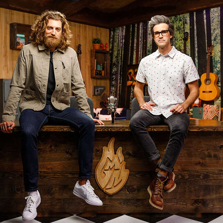 Rhett and Link sit on a desk. 