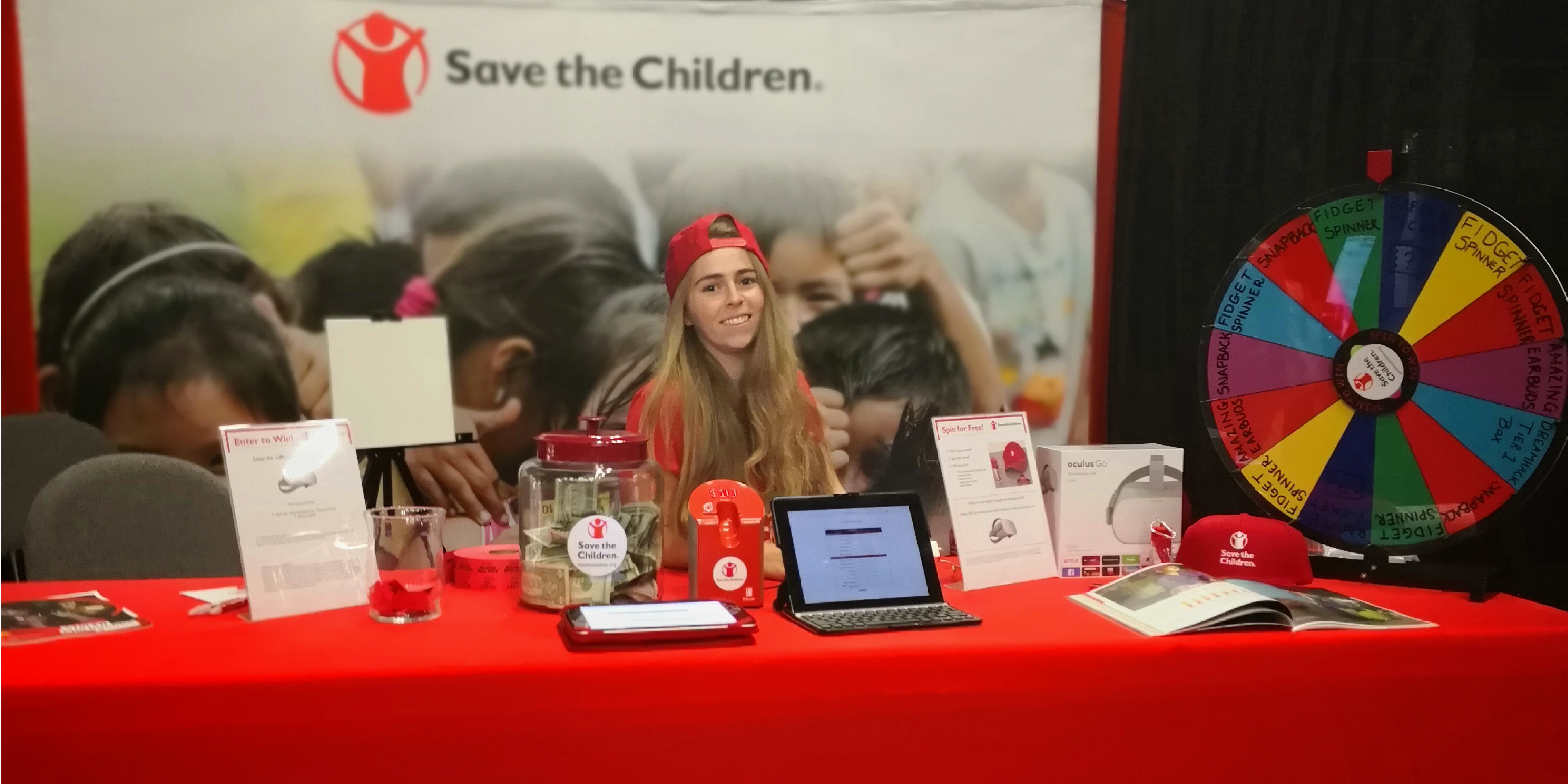 Save the Children staff member at a booth for a Stream Team event.