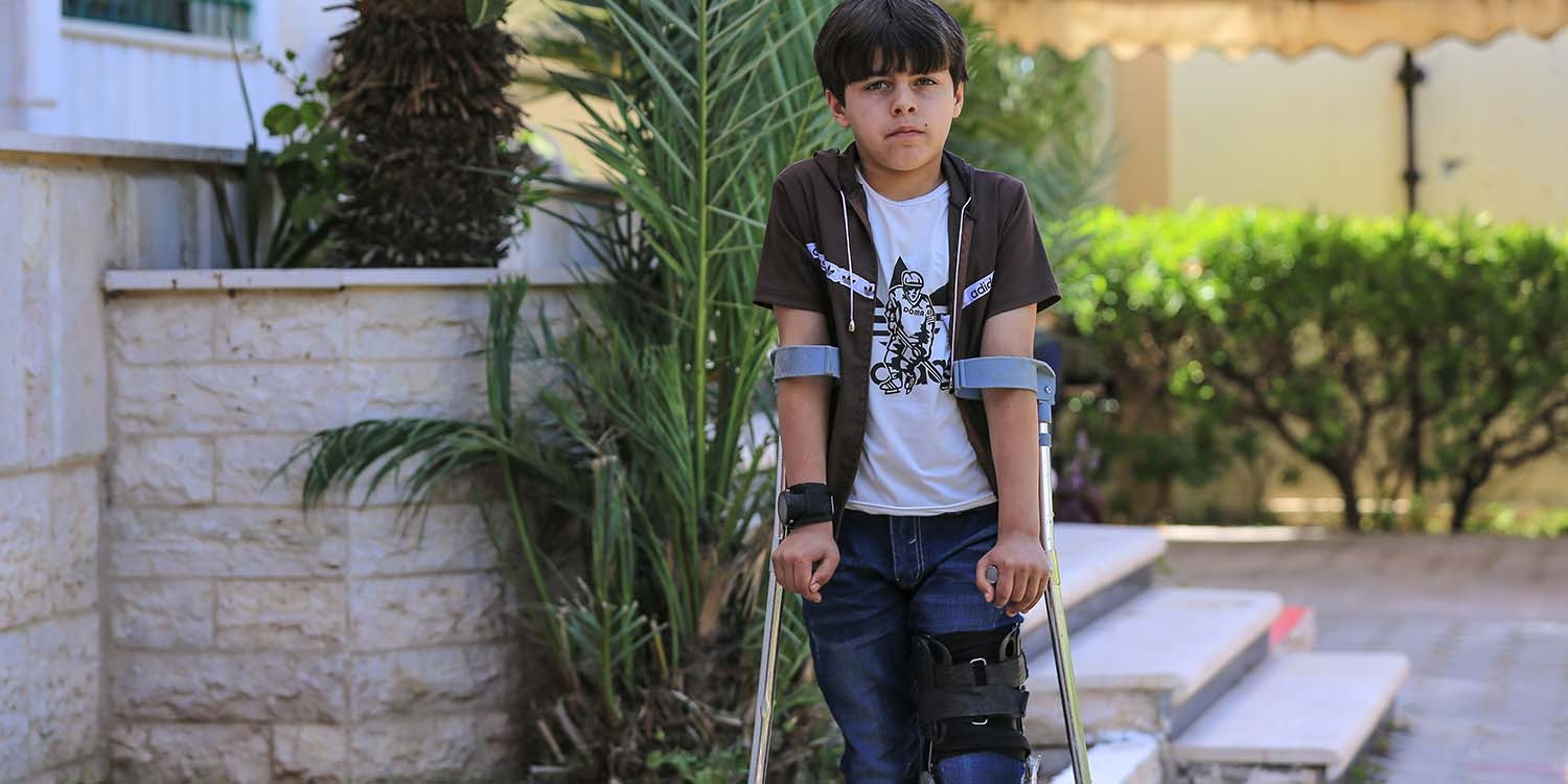 Palestine, a young boy on crutches steers into the camera