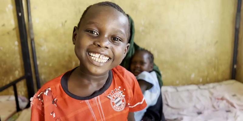 Sudan, a smiley, happy boy looks at the camera.