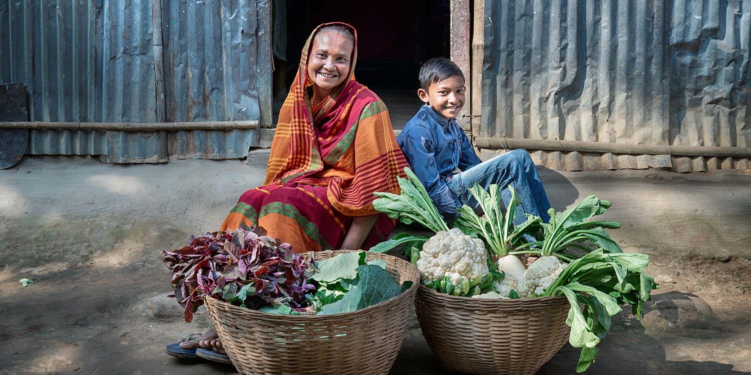 Bangladesh, a mother and son show off their home-grown vegetables