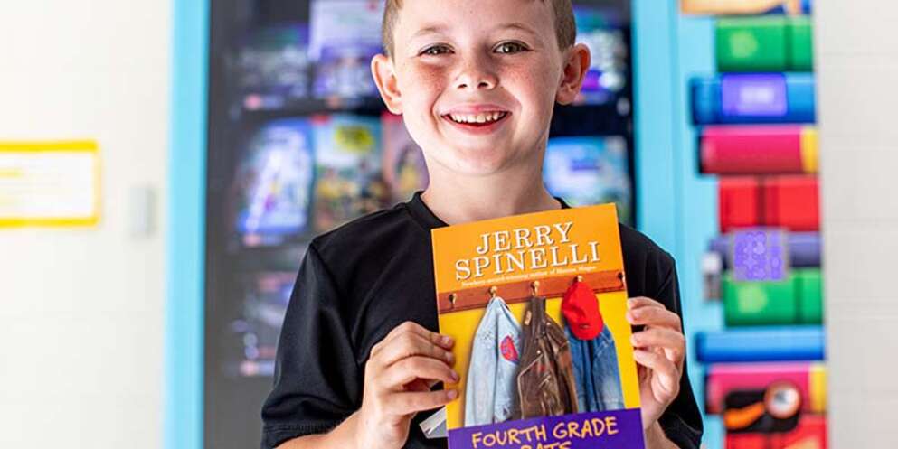 6 yr. old boy in Kentucky holding up a book from a book vending machine