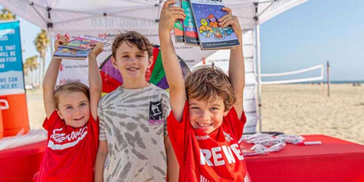 Kids show off Mad Lib books they received during the launch event for Save the Children’s annual summer reading campaign at Santa Monica beach in Los Angeles, California.