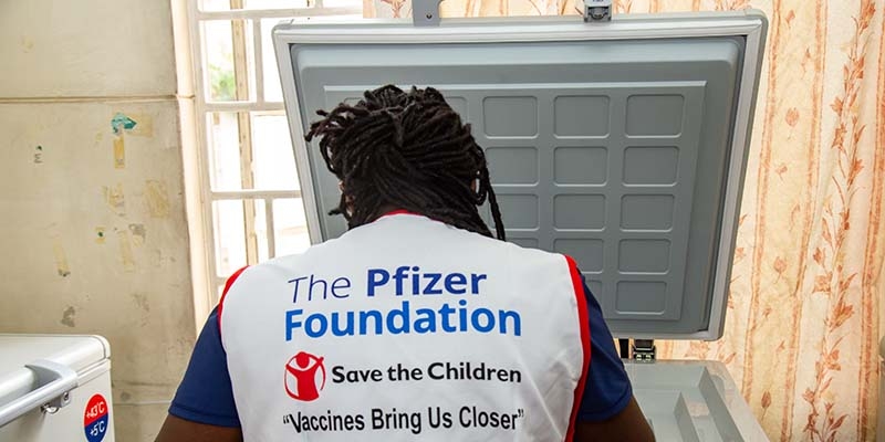 A Kenya, a Save the Children health worker wears a vest that reads: Pfizer Foundations