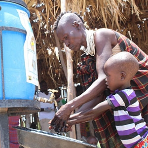 Jacinta, a resident from Central Turkana, washing hands of her child to curb the spread of Covid-19.