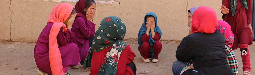 A group of girls in Afghanistan play a game where they cover their eyes. 