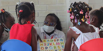 In Columbia, a teacher wears a facemask while teaching students the alphabet.