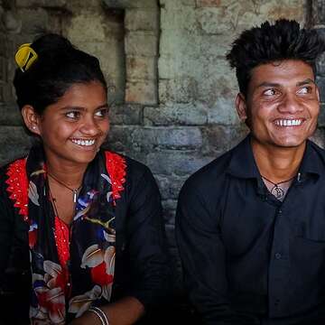 16-year-old Sonu and her 19-year-old brother Ganesh sit side-by-side with big smiles on their faces.
