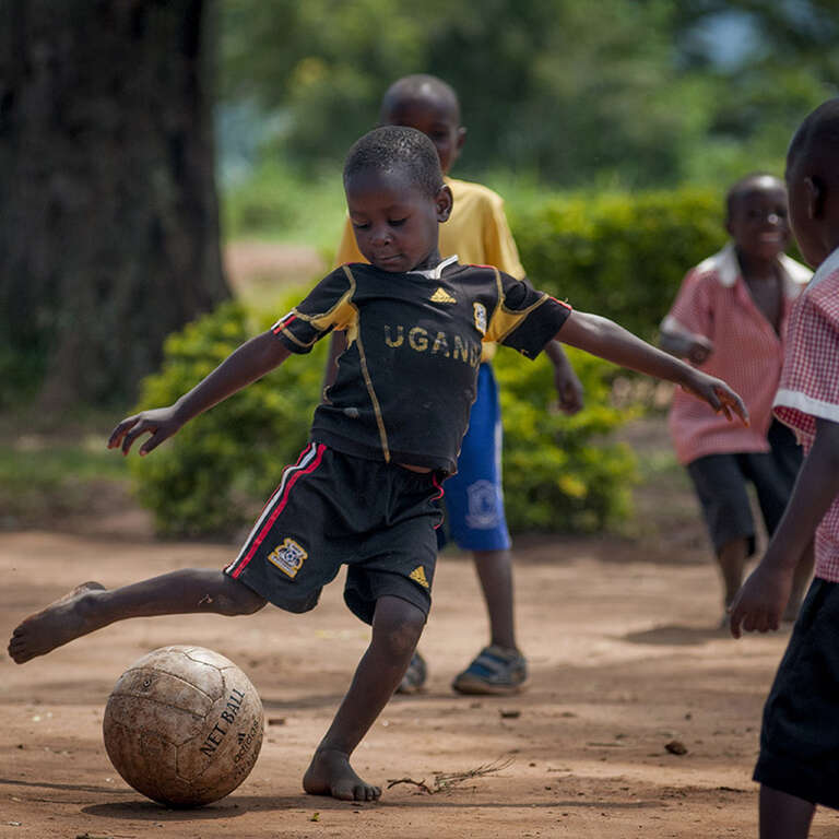 Wakiso, Uganda Children play football (soccer) on playground in Uganda.