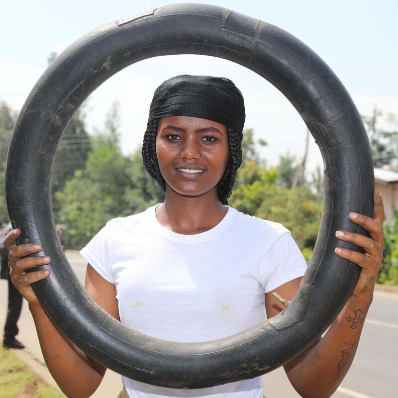 A girl holds a tire to demonstrate the skills she learned through Save the Children's Young Women's Leadership & Economics Empowerment Program (LEEP) in Ethiopia.