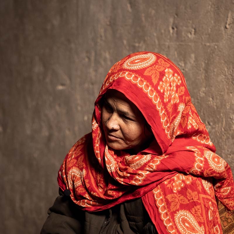 In Afghanistan, a mother sits in her home in a displacement camp following the death of her husband.