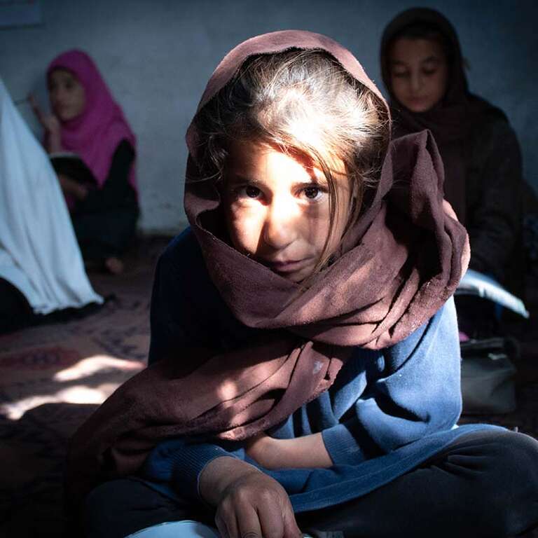 In Afghanistan, a 10-year old girl attends school in a community-based program after her school was closed due to conflict.