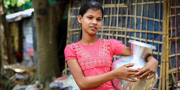 Ayesha* (12) holds a water container at Lambashia Camp, Cox’s Bazar, Bangladesh.