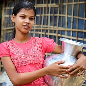Ayesha* (12) holds a water container at Lambashia Camp, Cox’s Bazar, Bangladesh.