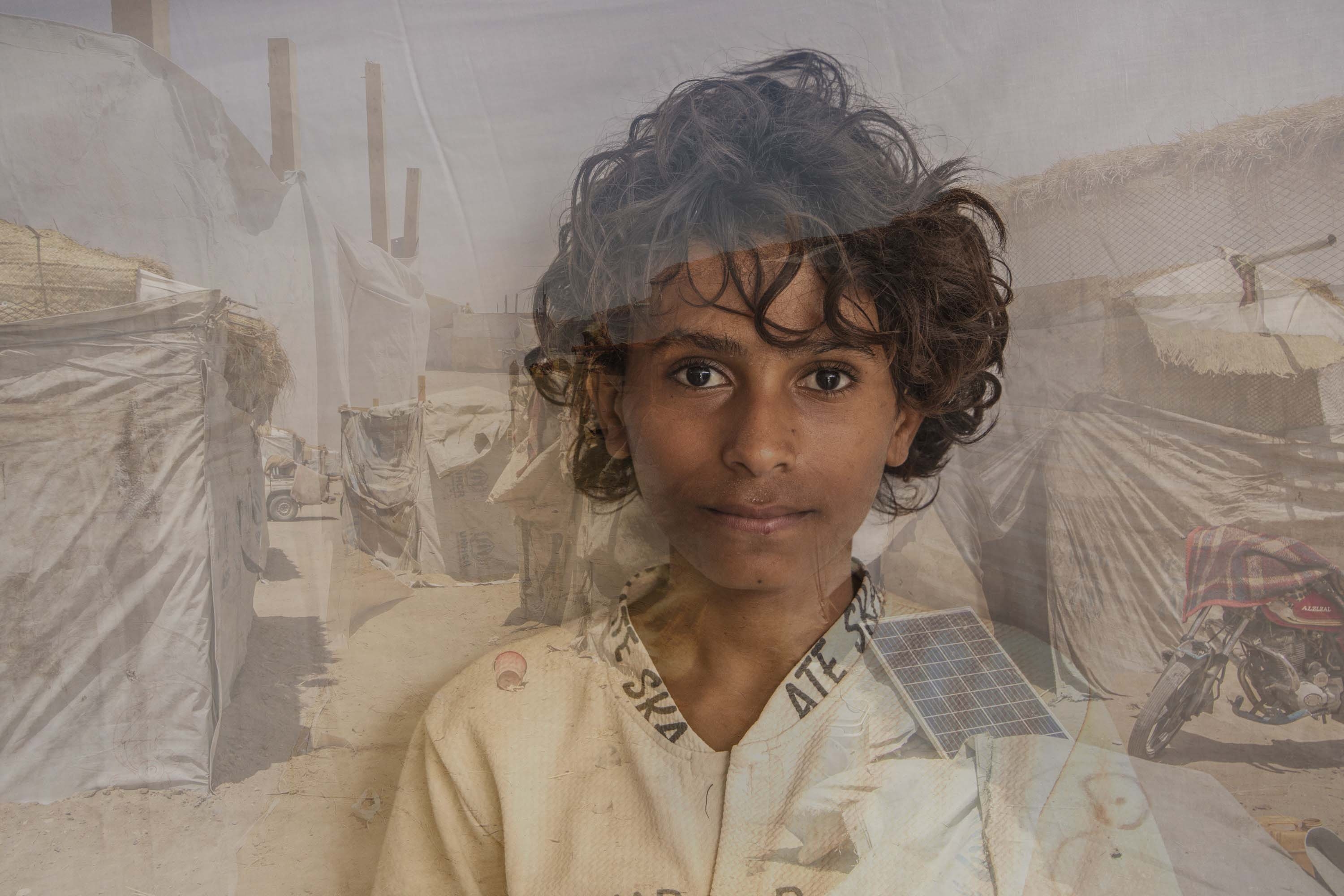 Yemen, a 14 yr. old boy stands in front of a displacement camp
