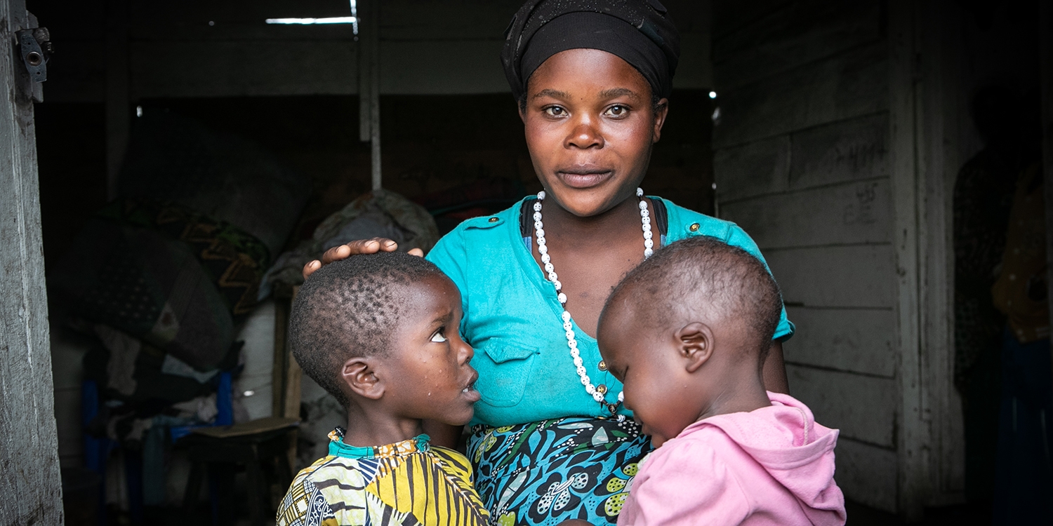 DRC, a single mother sits with her two children 