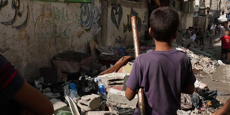 In Gaza, a boy faces a pile of rubble from buildings destroyed by the ongoing conflict. 