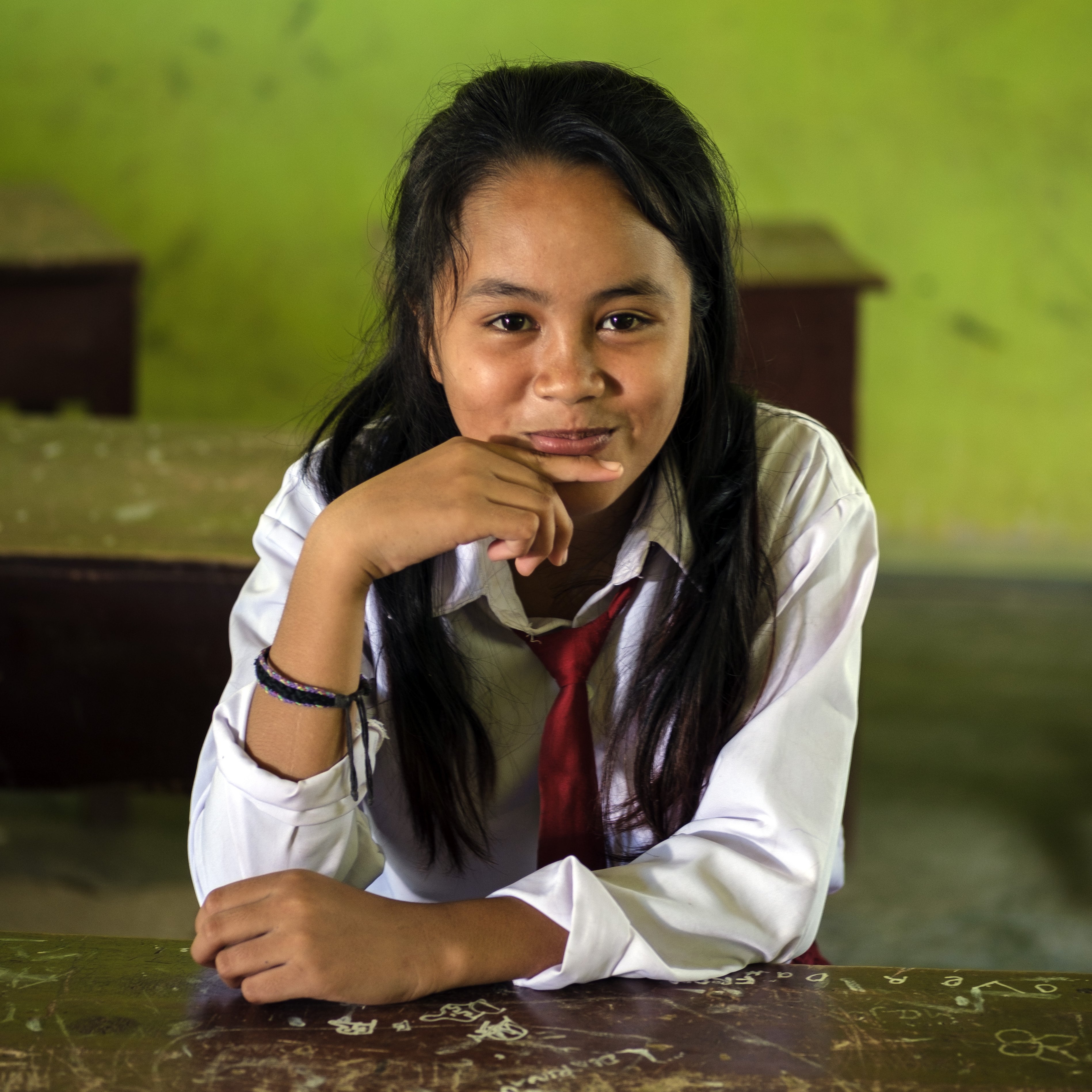 12-year old Marzela smiles while sitting at a desk in her elementary school Central Sulawesi, Indonesia. Marzela lost her home during the deadly 2018 Indonesia earthquake and tsunami. Her family received a multi-purpose grant from Save the Children to rebuild their lives. Photo credit: Jiro Ose / Save the Children, Feb 2019