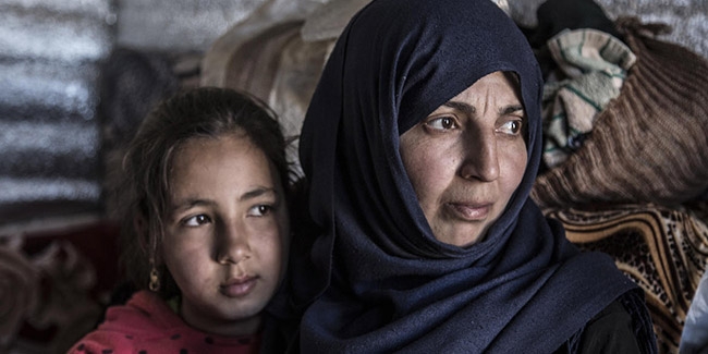 A mother and her daughter huddle close together in a shelter for Syrian refugees in Lebanon, which is currently experiencing an economic crisis.