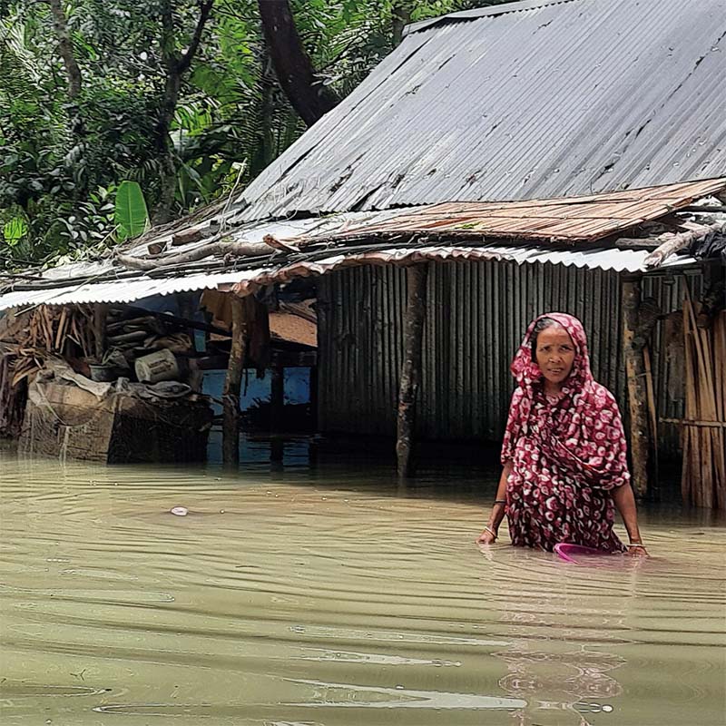 In Pakistan, a woman stands in waist-high waters following a deadly flood.
