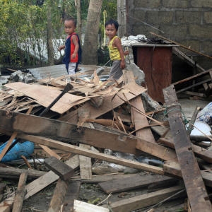 Limuel and John Deo walk through debris in what remains of their house after it was blown down by Typhoon Mangkhut. Credit: LJ Pasion/Save the Children