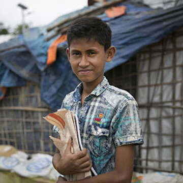 Tomal poses for a photo near his shelter. Tomal is a Rohingya refugee boy who lives with his grandparents in the Rohingya refugee camps in Cox's Bazar, Bangladesh. He lives with his grandparents as he thinks the education quality in their part of camp is better than in his parents who live in a different part of the camp. Photo credit: Allison Joyce / Save the Children, 2019.