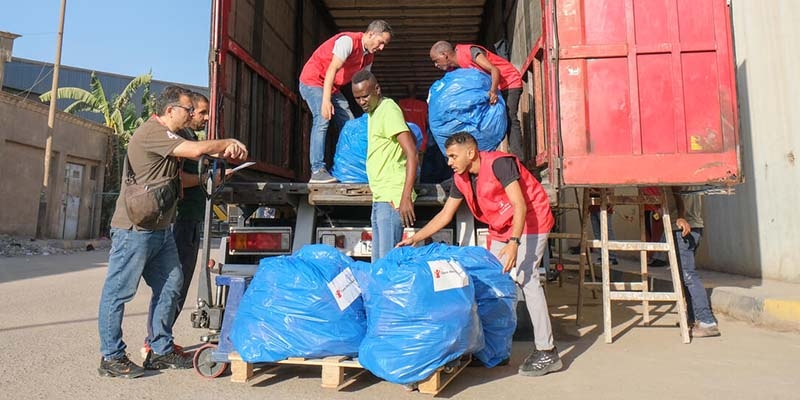 A truck filled with humanitarian aid for Gaza gets filled by Save the Children staffers. 
