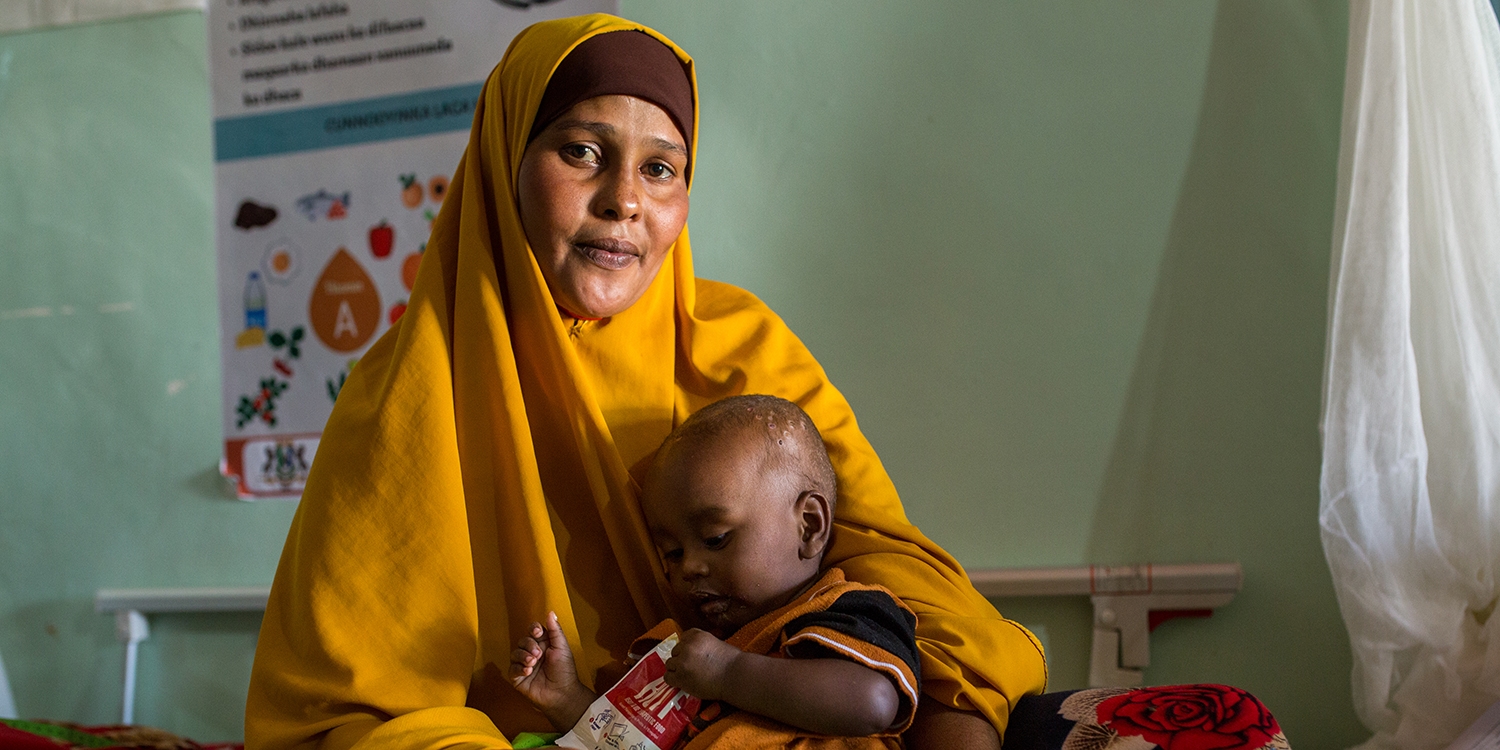 Somalia, a 10 month old baby is cradled by his mother after receiving therapeutic food