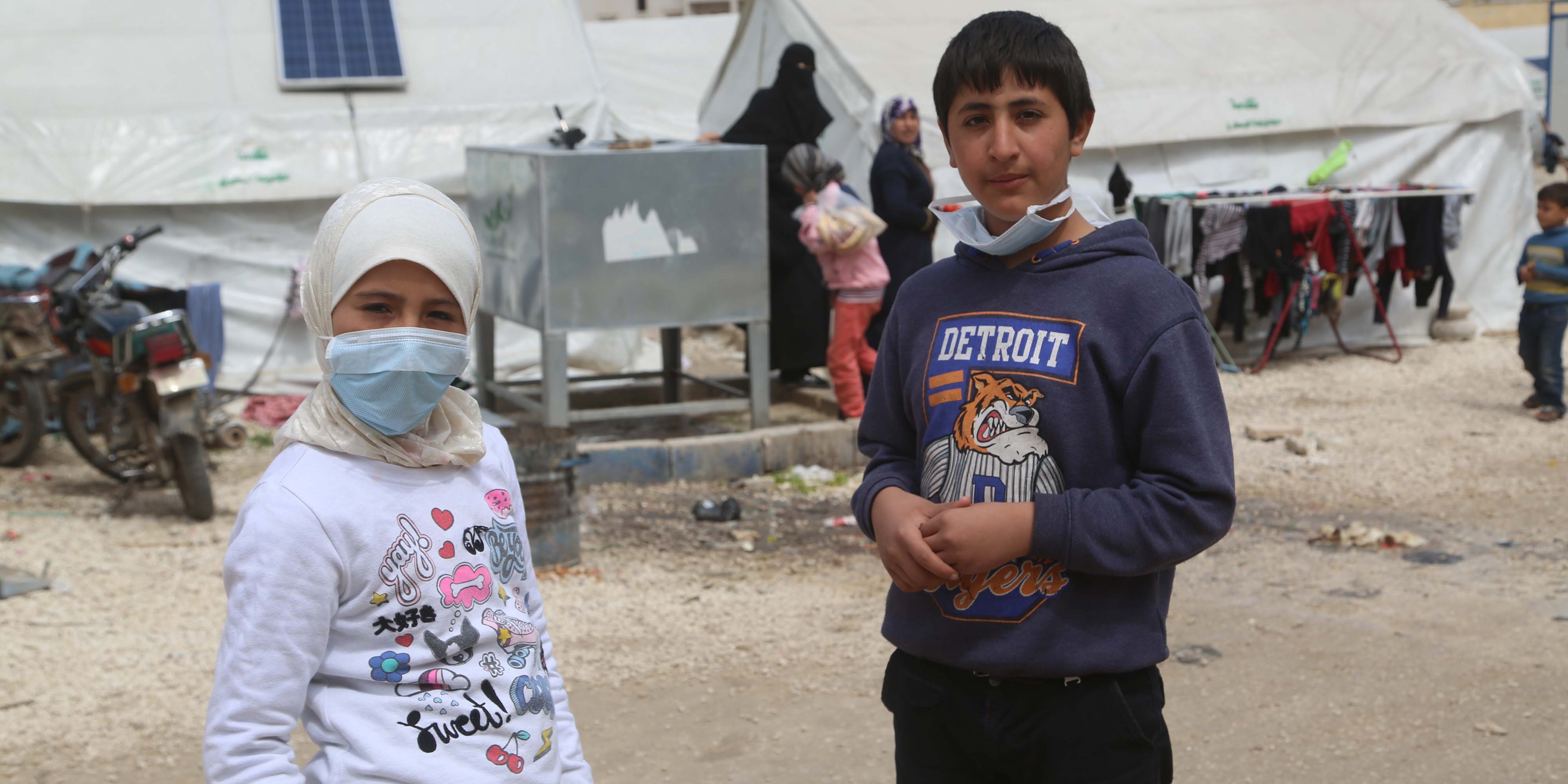 Syria, a brother and sister in a refugee camp look at the camera