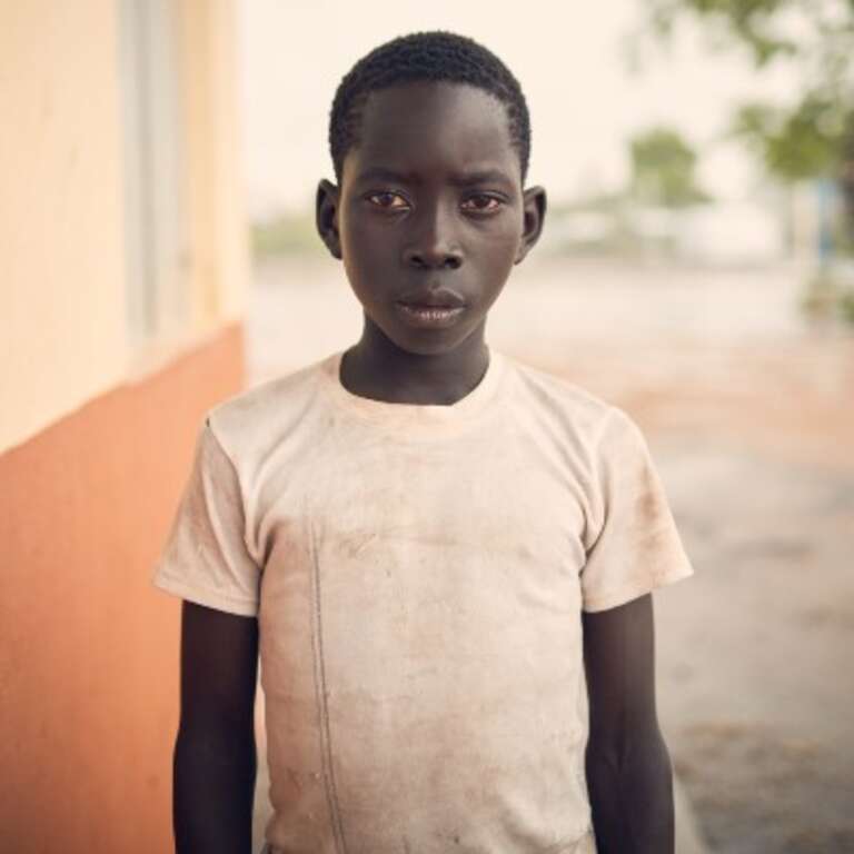 A 12-year old boy stands outside in Bidi Bidi refugee camp in Uganda. 