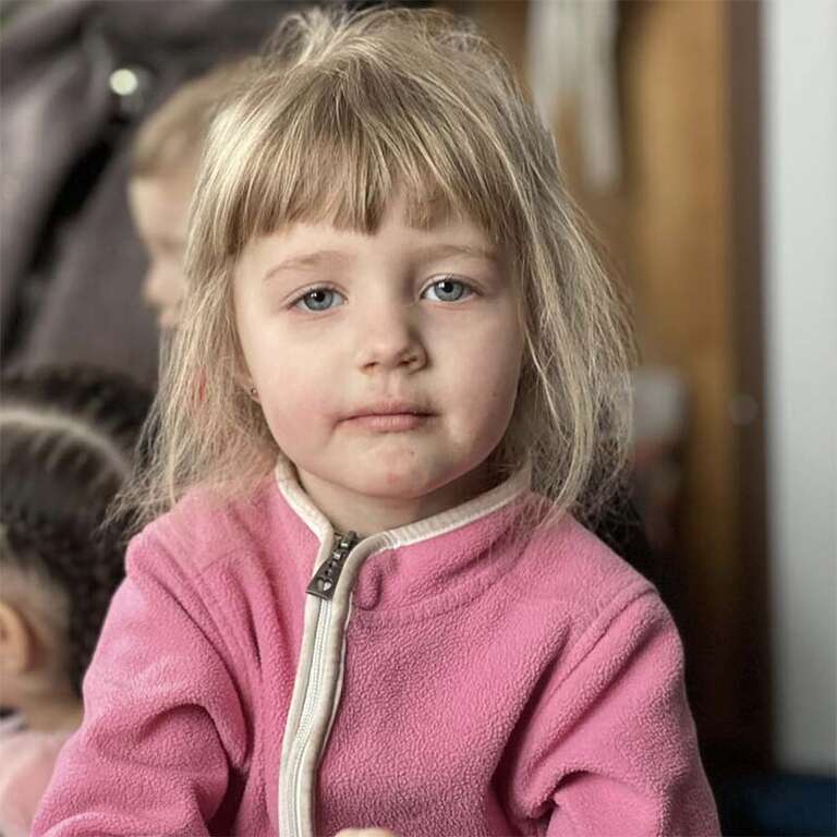 In Ukraine, a young girl takes a rest in a shelter for Ukraine refugees who have fled violent conflict at home.