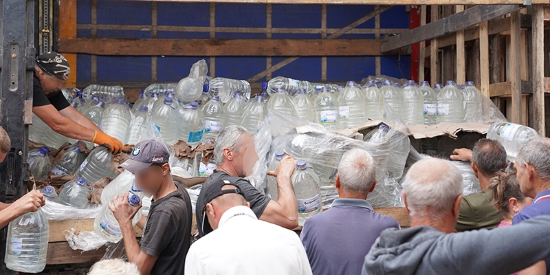Ukraine, local volunteers unload a truck with drinking water provided by Save the Children.