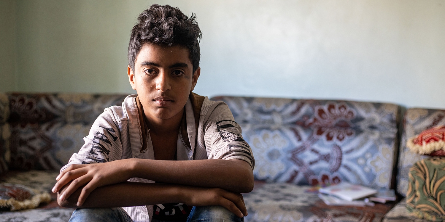 Yemen, a teenage boy who was hit by a sniper's bullet looks at the camera