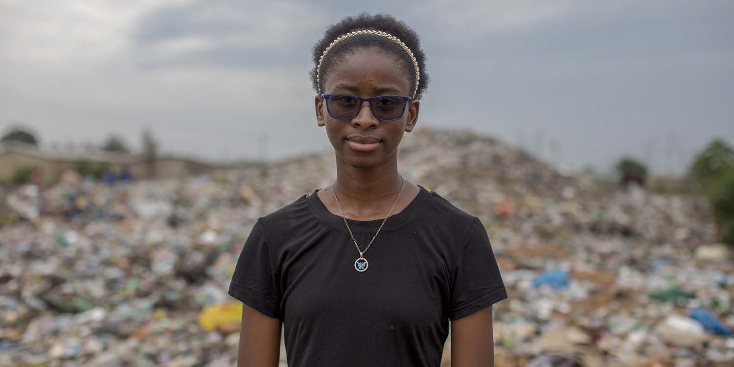 16-year-old Justina, a child climate activist, poses for the camera at the dumpsite in her community in Zambia.