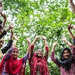 Young women in Bangladesh raise their hands to the sky