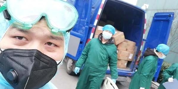 Local volunteers in Wuhan, China wear protective suiting while helping to load boxes of face masks donated by Save the Children onto a distribution truck. 