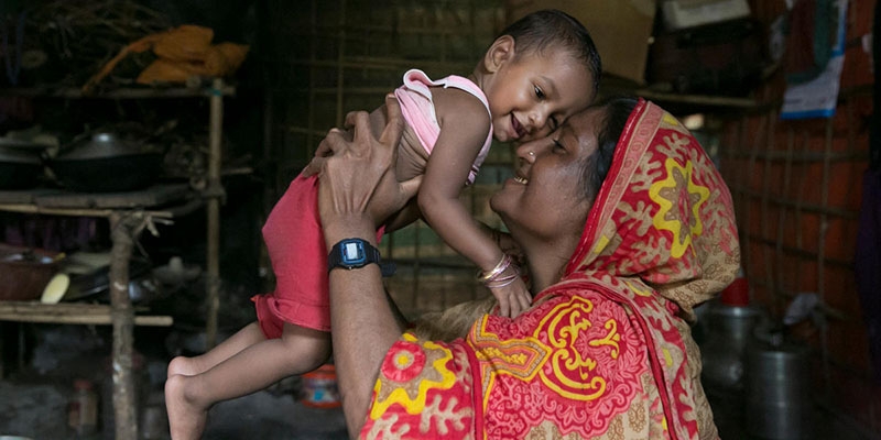 Cox's Bazar, Bangladesh, a mother holds her child after receiving treatment for malnourishment