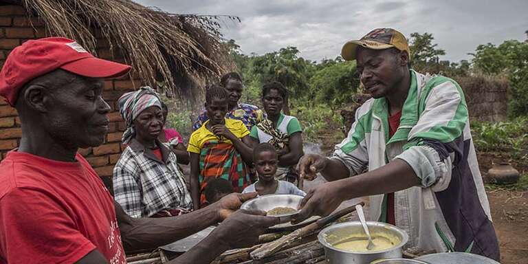 Local activists in Mozambique demonstrate cooking techniques for mothers.