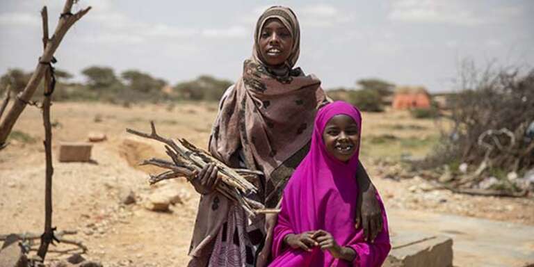 Two sisters hold firewood near their village in Somalia.