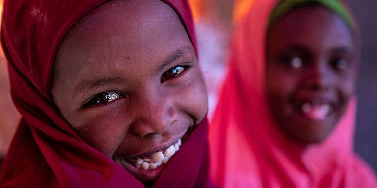 Two young girls smiling at the camera.