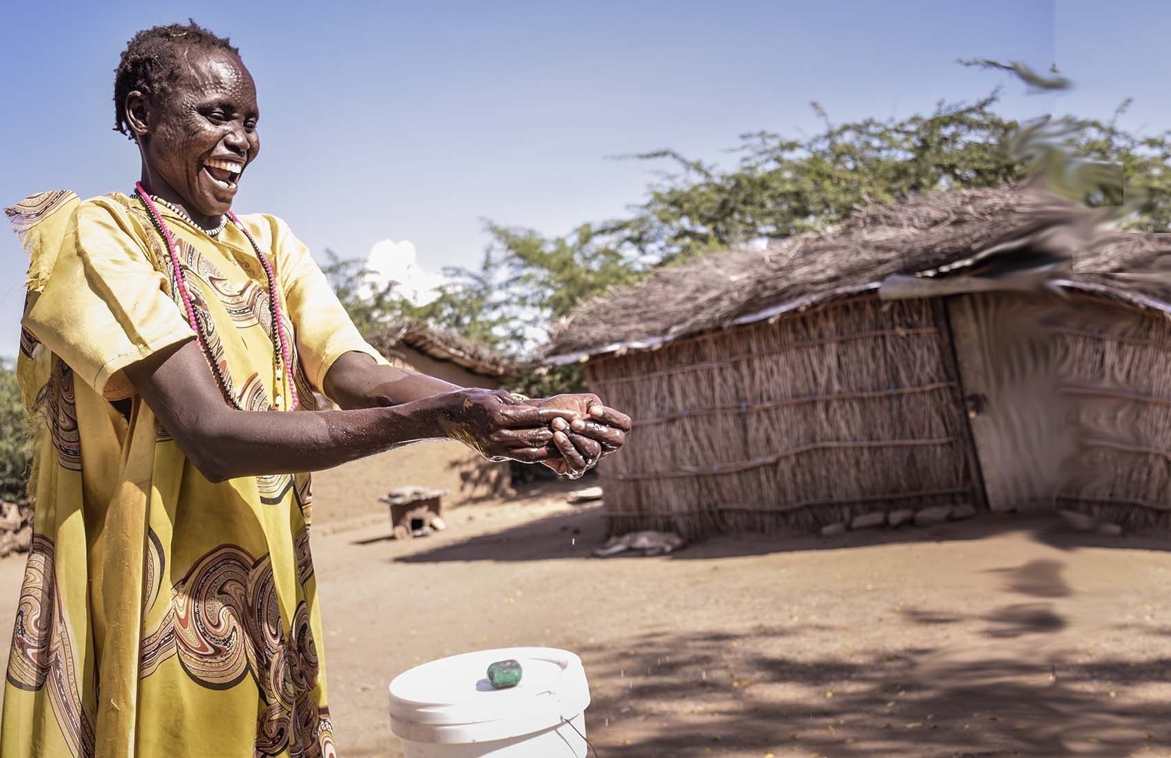 A woman in South Sudan washing her hands outdoors to prevent against the spread of COVID-19.