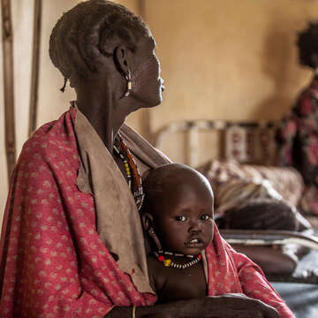 One year-old Hakaroom sits with his mother Lokuru at a Save the Children supported health centre in Kapoeta, South Sudan, after being treated for severe pneumonia.