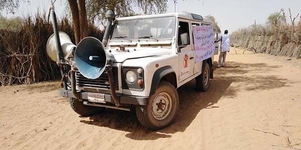 Save the Children Land Rover all terrain vehicle 4x4 with large megaphone spreads awareness messaging about COVID-19.