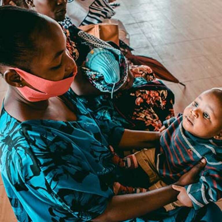 A mother holds her new baby inside a health clinic in Tanzania. 