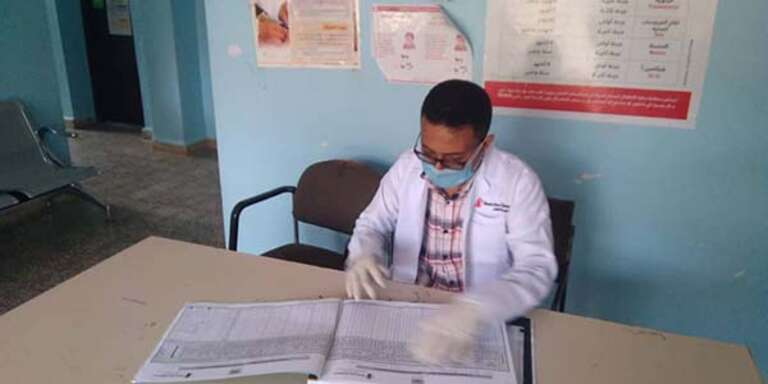 A doctor sitting at a desk in a health center in Yemen.