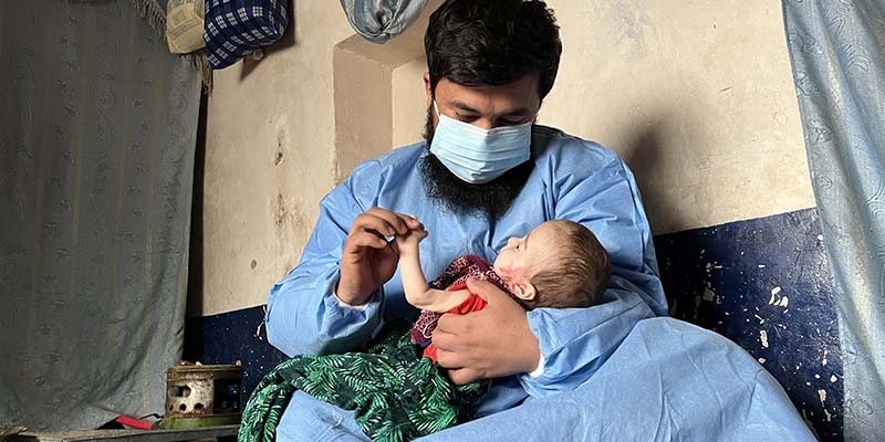 In Afghanistan, a doctor holds a baby who is malnourished due to the ongoing hunger crisis.
