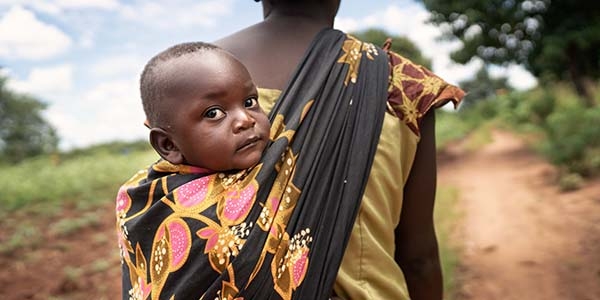Memory with her son Joseph in a sling on her back, in Malawi.