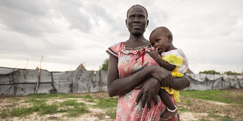 В Сомали мать держит на руках своего ребенка, которого лечат от недоедания. 